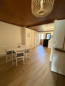 a dining room with a table and chairs and a chandelier at Face au chateau in Vizille +3 photos