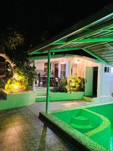a house with a green pool in front of it at Cozy Skyview Villa in Lopez Quezon! in Lopez