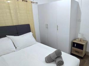 a bedroom with a white bed and a cabinet at Cosy Homes in Suva - 2BR Family Unit in Suva