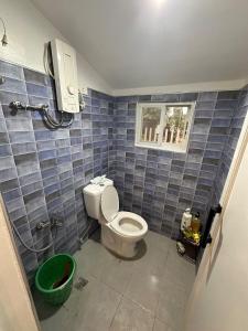a bathroom with a toilet and a window at Cozy Skyview Villa in Lopez Quezon! in Lopez