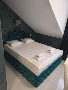 ein Schlafzimmer mit einem Bett mit blauem Kopfteil in der Unterkunft Maciejowa Chata Stare Lubiejewo in Ostrów Mazowiecka