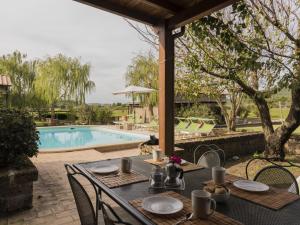 un tavolo e delle sedie accanto a una piscina di Apartment Casa Domenico 2 by Interhome a Montefiascone