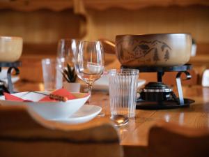 een houten tafel met glazen en een bord eten bij Apartment Chäs Gruebi Apt-S by Interhome in Wengen