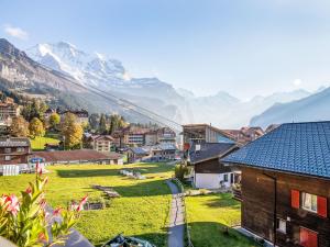 a small village with mountains in the background at Apartment Chäs Gruebi Apt-S by Interhome in Wengen +30 photos