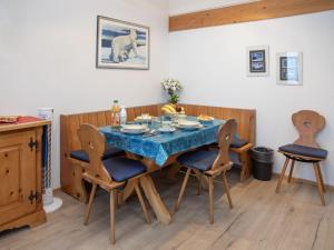 a dining room with a blue table and chairs at Apartment Breithorn Residence Apt-09 by Interhome in Wengen