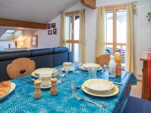 a table with a blue table cloth and plates on it at Apartment Breithorn Residence Apt-09 by Interhome in Wengen