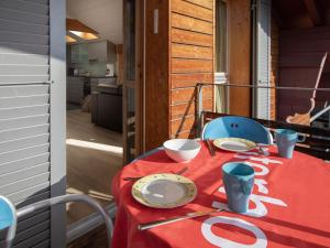a table with a red table cloth and plates on it at Apartment Breithorn Residence Apt-09 by Interhome in Wengen