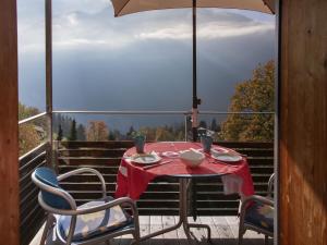 a table and chairs on a balcony with an umbrella at Apartment Breithorn Residence Apt-09 by Interhome in Wengen