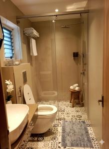 a bathroom with a shower and a toilet and a sink at Klyra Hotel in Hyderabad
