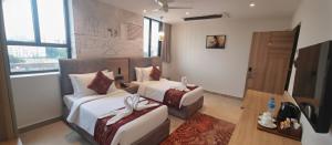 a hotel room with two beds and a couch at Klyra Hotel in Hyderabad