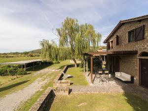 een bakstenen huis met een patio naast een rivier bij Apartment Casa Domenico n- 1 by Interhome in Montefiascone