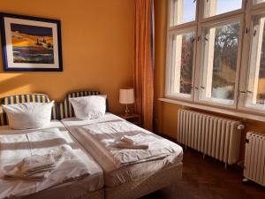 two beds in a room with two windows at Villa am Peetzsee Unterkunft am See in Grünheide mit Parkplatz, Self Check-in, Küche, WLAN, Nähe Tesla Berlin in Schlangenluch