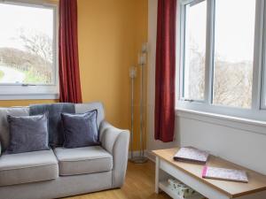 a living room with a couch and two windows at Holiday Home Alan's House by Interhome in Staffin +24 photos