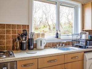 a kitchen counter with a sink and a window at Holiday Home Alan's House by Interhome in Staffin