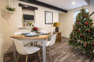 Poachers Cottage في ليبرن: غرفة طعام مع طاولة وشجرة عيد الميلاد