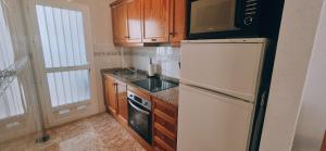 una cucina con frigorifero bianco e forno a microonde di apartamento Punta Prima cinuelica a Los Altos