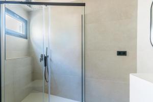 a shower with a glass door in a bathroom at Suite Plaza Nueva in Seville +11 photos