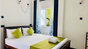 a bedroom with a bed with a window at Casamia Tangalle - Relaxing Cozy Homestay Hiriketiya in Sinimodera +11 photos
