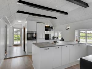 a kitchen with white cabinets and a counter top at Holiday Home Giesela - 975m from the sea by Interhome in Ringkøbing