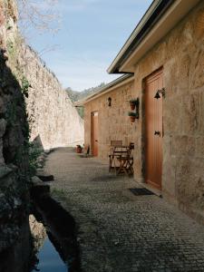 a stone building with a wooden door and a table at Quinta de Recião in Lamego