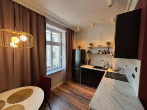 Una cocina con una mesa, un fregadero y una encimera. en Just in Stary Rynek, en Bydgoszcz