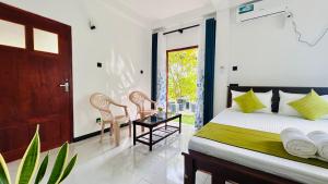 a bedroom with a bed and a table and chairs at Casamia Tangalle - Relaxing Cozy Homestay Hiriketiya in Sinimodera