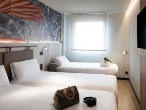 a hotel room with two beds with a purse on the bed at ibis Styles Santander in Santander +143 photos