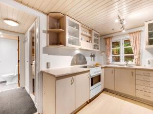 Una cocina con gabinetes blancos y un fregadero. en Holiday Home Brawith - 700m to the fjord by Interhome, en Ringkøbing