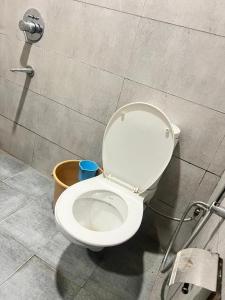 ein weißes WC im Bad mit Eimer in der Unterkunft Hotel Park land in Zirakpur