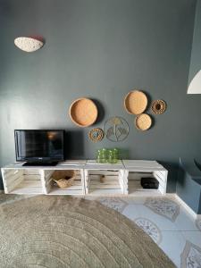 a living room with a tv and baskets on the wall at B4 Apartment Stone Town in Zanzibar City