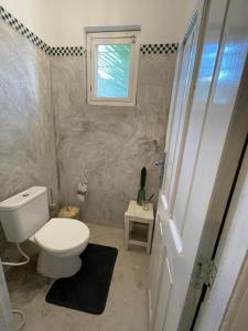 a small bathroom with a toilet and a window at B4 Apartment Stone Town in Zanzibar City +13 photos