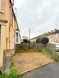 a yard next to a house with a fence at Lorne House-Near Centre-Free Parking-Sleeps 8 in Bath