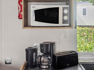 a microwave on a shelf above a kitchen counter at Green harmony in Litteau