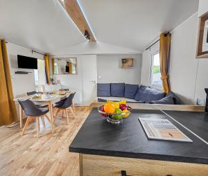 a kitchen and living room with a bowl of fruit on a counter at Green harmony in Litteau
