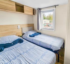two beds in a small room with a window at Green harmony in Litteau