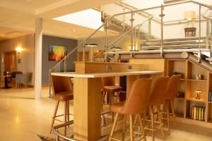 a bar in the middle of a room with stools at Great National Ballykisteen Golf Hotel in Limerick Junction +44 photos