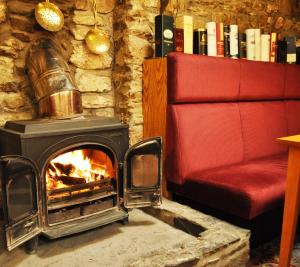 sala de estar con chimenea y sofá rojo en The Galley Of Lorne Inn, en Ardfern