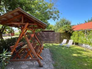 a wooden play structure in a yard with two chairs at Apartment Pajtas 1 by Interhome in Balatonfenyves