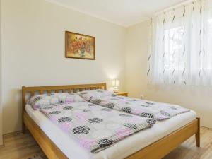 a bed with a quilt on it in a bedroom at Apartment Pajtas 1 by Interhome in Balatonfenyves
