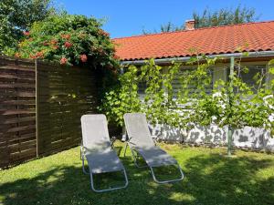 two chairs sitting in a yard next to a fence at Apartment Pajtas 1 by Interhome in Balatonfenyves