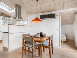 a kitchen and dining room with a table and chairs at Holiday Home Skarthi - 200m from the sea by Interhome in Sæby