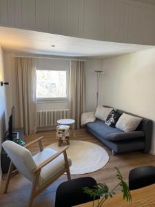 a living room with a blue couch and a table at Ferienwohnung Monya in Sörenberg