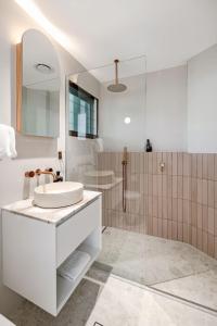 une salle de bain blanche avec lavabo et douche dans l'établissement Bella Vista Noosa Luxury on White Sands, à Noosaville 44 autres photos