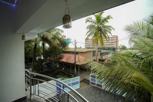 阿勒皮Sukhalaya Lake Villa的阳台享有建筑和棕榈树的景致。