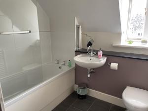 een badkamer met een wastafel, een toilet en een douche bij Moat House 6 in Fort Augustus +14 foto's
