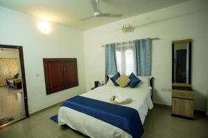 阿勒皮Sukhalaya Lake Villa的卧室里有一张大床，配有蓝色枕头