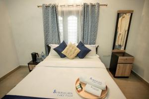 阿勒皮Sukhalaya Lake Villa的一间卧室,配有一张带一盘食物的床