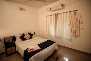 阿勒皮Sukhalaya Lake Villa的卧室配有一张床,墙上挂着长袍 更多5张照片