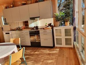 a kitchen with white cabinets and a stove top oven at Garden Oasis In Bern in Liebefeld
