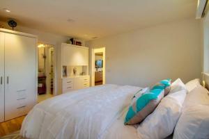 a bedroom with a large white bed with pillows at Sunset Beach in Encinitas